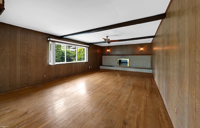 19300 Briarwood St, Clinton Township, MI 48036 - unfurnished living room featuring a ceiling fan, wood walls, wood finished floors, a fireplace, and beamed ceiling