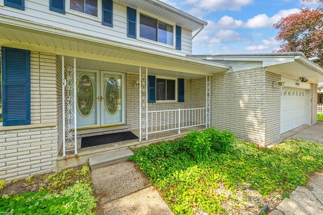 19300 Briarwood St, Clinton Township, MI 48036 - view of exterior entry with brick siding, covered porch, a garage, and asphalt driveway