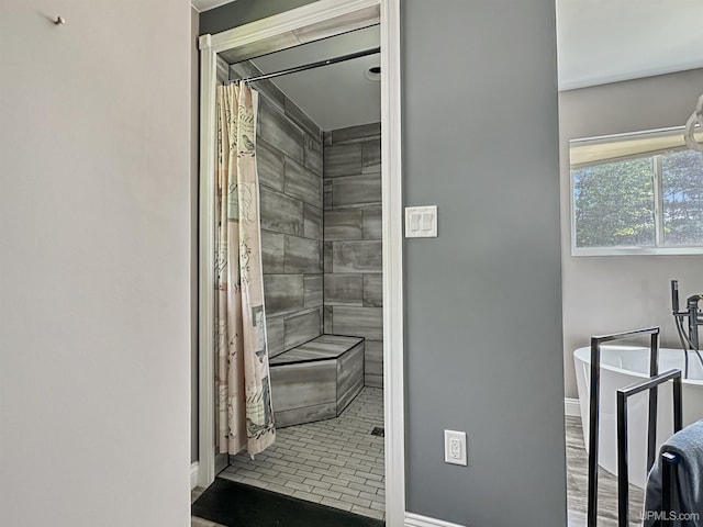 8302 W Burntwood P.15 Dr, Gladstone, MI 49837 - bathroom featuring a tile shower and baseboards