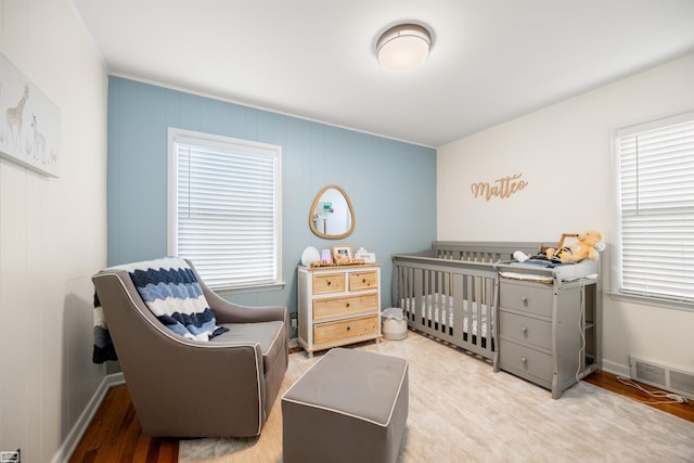 1006 W 12 Mile Rd, Royal Oak, MI 48073 - bedroom with multiple windows, a crib, and wood finished floors