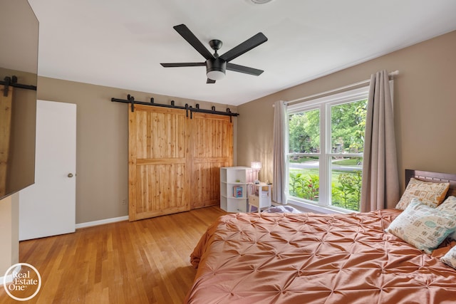 1033 Cadieux Rd, Grosse Pointe, MI 48230 - bedroom with a barn door, wood finished floors, and ceiling fan