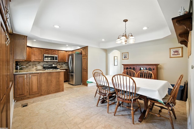 5350 Fieldcrest Dr, Shelby Twp, MI 48316 - dining area featuring a raised ceiling, arched walkways, recessed lighting, and a chandelier