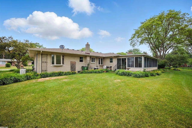 5350 Fieldcrest Dr, Shelby Twp, MI 48316 - rear view of property with a sunroom, a chimney, a lawn, and brick siding