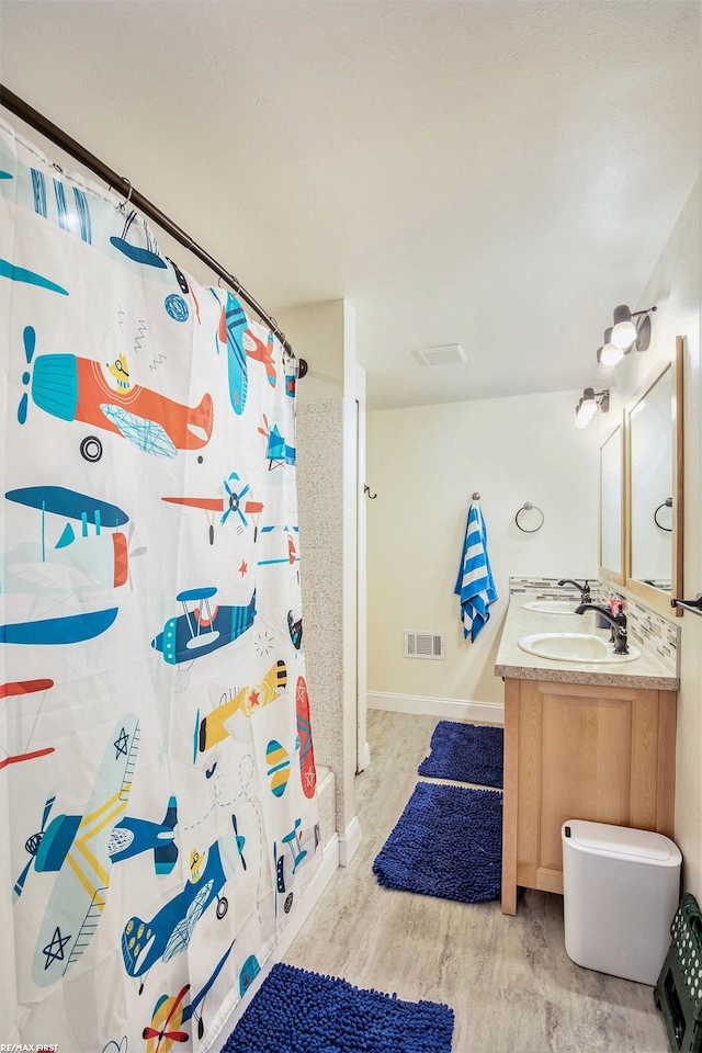 46329 Community Center Dr, Chesterfield Twp, MI 48047 - full bathroom with double vanity, wood finished floors, and a shower with shower curtain