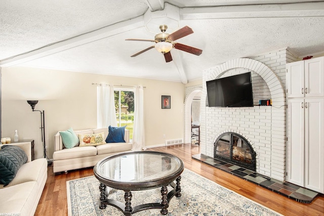 46329 Community Center Dr, Chesterfield Twp, MI 48047 - living area featuring a ceiling fan, wood finished floors, a brick fireplace, and a textured ceiling