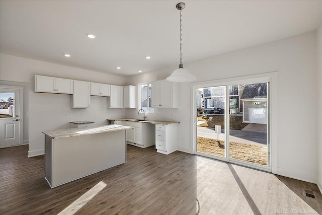 1718 W 12 Mile Rd, Royal Oak, MI 48073 - kitchen with healthy amount of natural light, white cabinets, dark wood finished floors, and recessed lighting