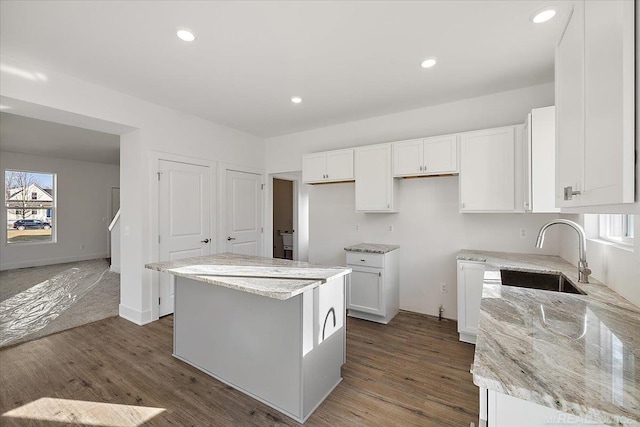 1718 W 12 Mile Rd, Royal Oak, MI 48073 - kitchen featuring a center island, white cabinets, light stone counters, wood finished floors, and recessed lighting