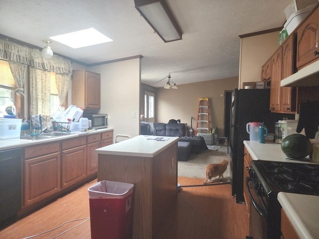811 N Old State Ave, Harrison, MI 48625 - kitchen with appliances with stainless steel finishes, light wood-type flooring, a center island, light countertops, and a skylight