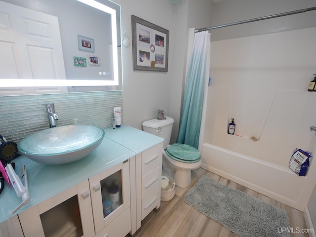 2004 Hunters Ln, Houghton, MI 49931 - full bath with backsplash, vanity, shower / bath combination with curtain, and wood finished floors