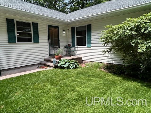 2004 Hunters Ln, Houghton, MI 49931 - doorway to property with a lawn and a shingled roof