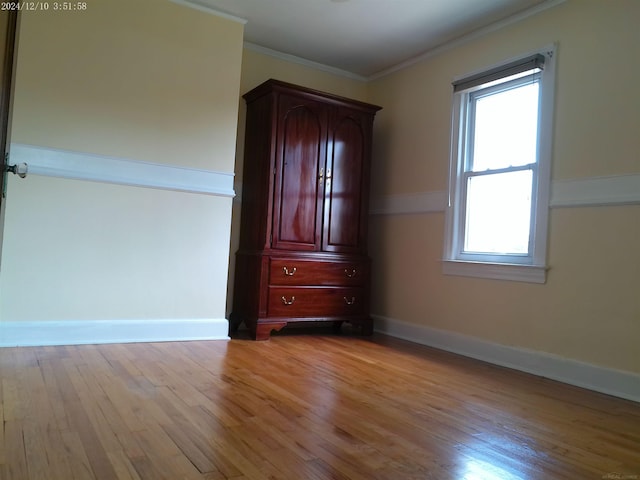 15553 Mclain Ave, Allen Park, MI 48101 - unfurnished bedroom featuring multiple windows, light wood-type flooring, and crown molding