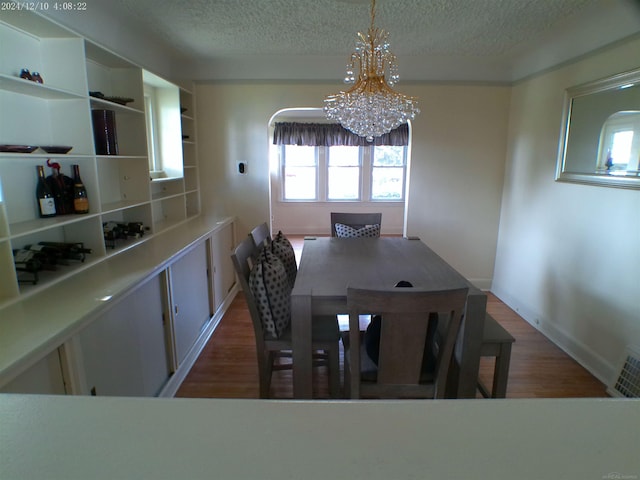 15553 Mclain Ave, Allen Park, MI 48101 - dining space featuring a chandelier, a textured ceiling, and wood finished floors