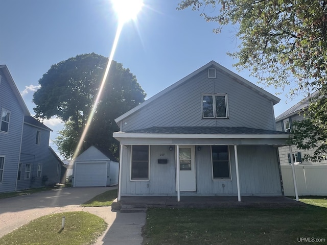209 N 10th St, Escanaba, MI 49829 - view of front facade featuring covered porch, an outdoor structure, driveway, a garage, and a front lawn