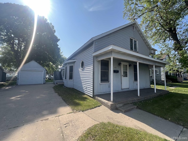 209 N 10th St, Escanaba, MI 49829 - view of front of property featuring covered porch, an outdoor structure, and a detached garage