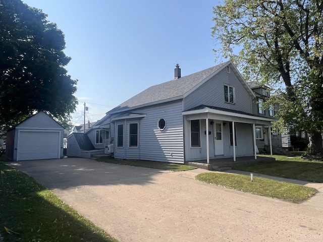 209 N 10th St, Escanaba, MI 49829 - view of front of home featuring covered porch, an outbuilding, a detached garage, asphalt driveway, and a chimney