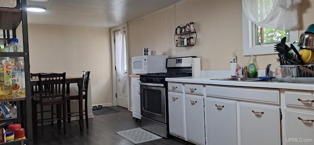 309 Fir St, Munising, MI 49862 - kitchen featuring stainless steel gas range oven, white microwave, light countertops, dark wood-style flooring, and white cabinets