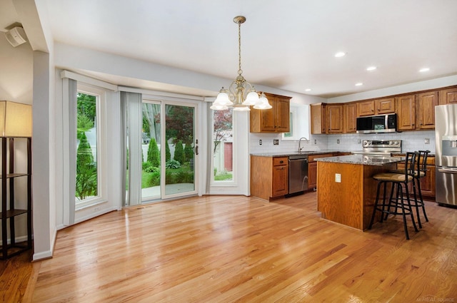 24781 Camille St, Harrison Twp, MI 48045 - kitchen featuring appliances with stainless steel finishes, brown cabinets, decorative backsplash, light wood-type flooring, and recessed lighting