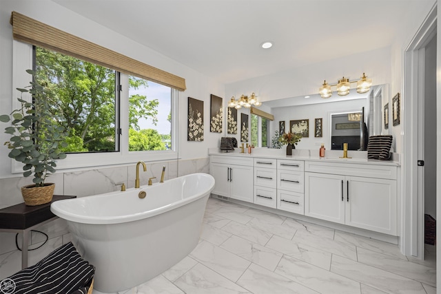 54877 Camden Ct, Shelby Twp, MI 48316 - full bath featuring marble finish floors, double vanity, healthy amount of natural light, a freestanding tub, and recessed lighting