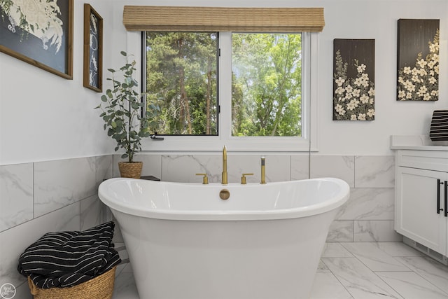 54877 Camden Ct, Shelby Twp, MI 48316 - full bathroom with tile walls, marble finish floors, a freestanding tub, vanity, and wainscoting