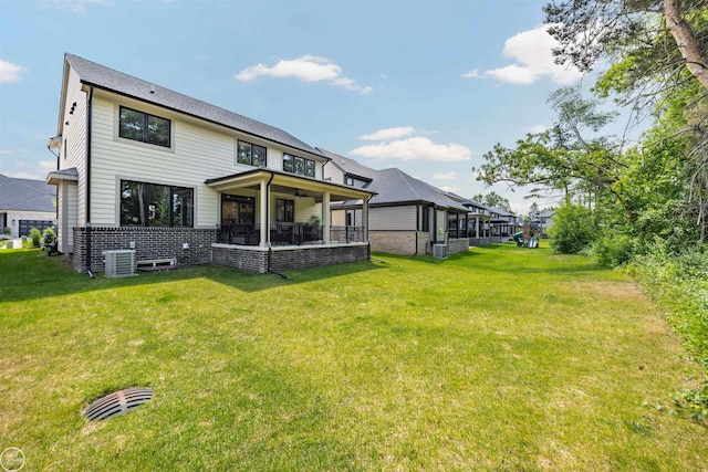 54877 Camden Ct, Shelby Twp, MI 48316 - rear view of house featuring ceiling fan, a lawn, and brick siding