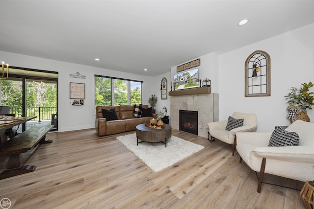 54877 Camden Ct, Shelby Twp, MI 48316 - living area with light wood finished floors, a tiled fireplace, and recessed lighting