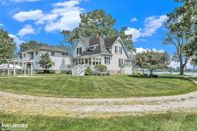 1520 S Channel Dr, Harsens Island, MI 48028 - view of front of house featuring a front lawn, a chimney, and roof with shingles