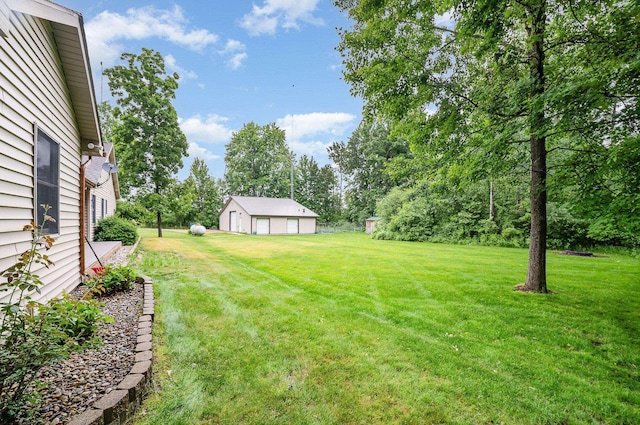 6242 N Geneva Rd, Coleman, MI 48618 - view of green lawn featuring a garage and view of wooded area