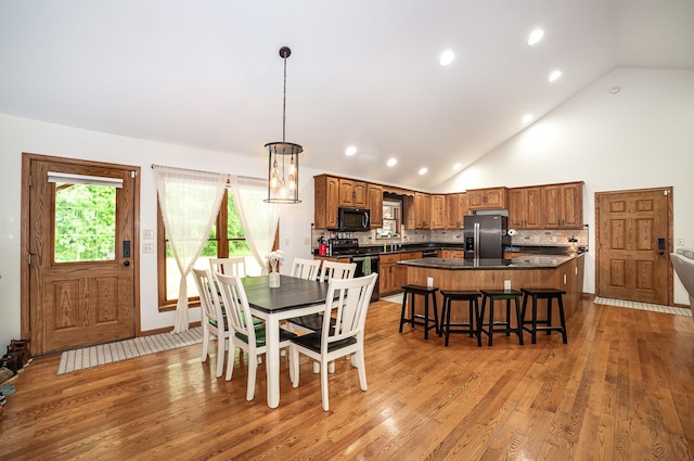 6242 N Geneva Rd, Coleman, MI 48618 - dining room featuring light wood-style flooring, recessed lighting, a chandelier, and high vaulted ceiling