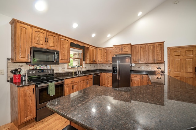 6242 N Geneva Rd, Coleman, MI 48618 - kitchen with stainless steel appliances, vaulted ceiling, tasteful backsplash, recessed lighting, and brown cabinetry