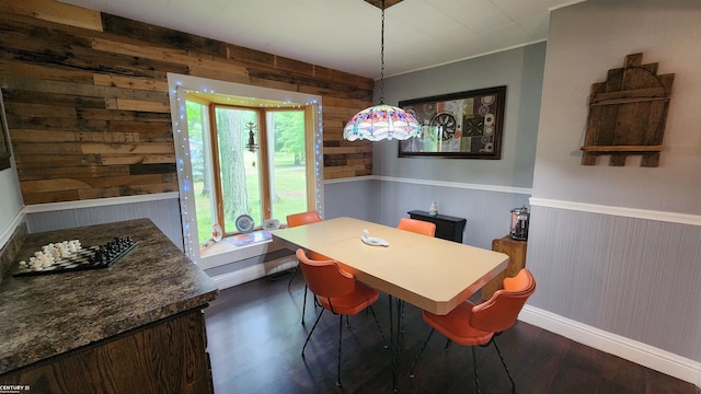 4467 Kings Corner Rd, Glennie, MI 48737 - dining space featuring wooden walls, dark wood-type flooring, and a wainscoted wall