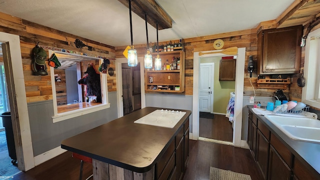 4467 Kings Corner Rd, Glennie, MI 48737 - kitchen featuring wood walls, white stovetop, dark wood-style flooring, dark brown cabinetry, and decorative light fixtures