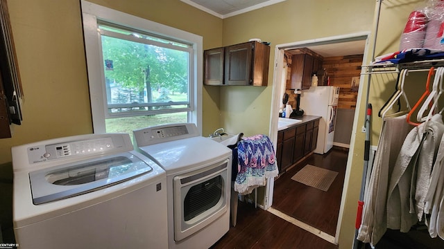 4467 Kings Corner Rd, Glennie, MI 48737 - laundry room featuring separate washer and dryer, dark wood-type flooring, cabinet space, and ornamental molding