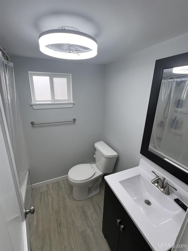 206 Cherry St, Munising, MI 49862 - bathroom with vanity, wood finished floors, and shower / bath combo with shower curtain
