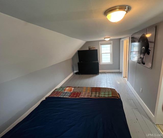 206 Cherry St, Munising, MI 49862 - unfurnished bedroom featuring hardwood / wood-style flooring and vaulted ceiling