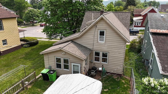 206 Cherry St, Munising, MI 49862 - back of property with a shingled roof, a fenced backyard, and a chimney