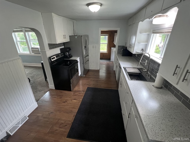 206 Cherry St, Munising, MI 49862 - kitchen with appliances with stainless steel finishes, wainscoting, tasteful backsplash, white cabinetry, and open shelves