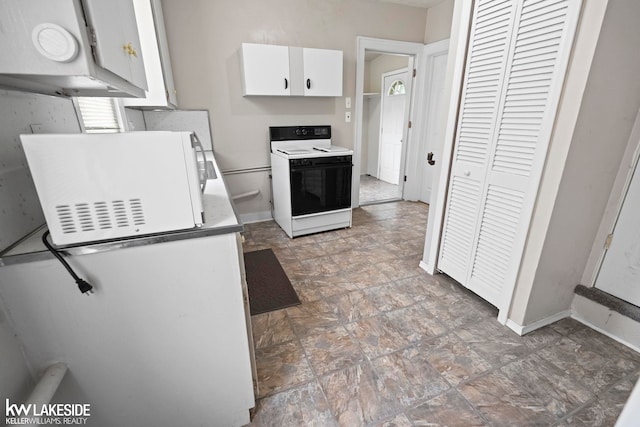 3620 Campbell St, Dearborn, MI 48124 - kitchen featuring range with electric stovetop, white microwave, white cabinetry, and stone finish floors