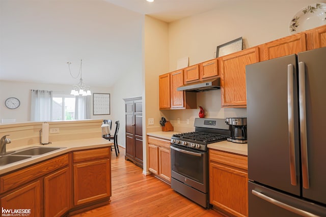56798 Winding Creek Dr, Macomb, MI 48042 - kitchen featuring appliances with stainless steel finishes, under cabinet range hood, vaulted ceiling, light countertops, and light wood finished floors