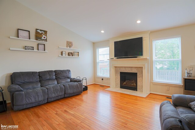 56798 Winding Creek Dr, Macomb, MI 48042 - living area with light wood-style floors, plenty of natural light, a tiled fireplace, recessed lighting, and vaulted ceiling