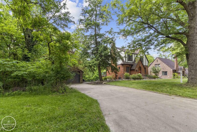 35727 Elm St, Wayne, MI 48184 - view of front of house with a front yard, a garage, brick siding, and driveway