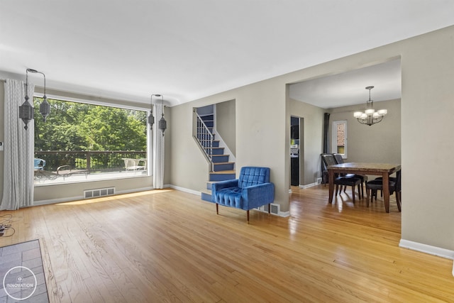 35727 Elm St, Wayne, MI 48184 - living area featuring hardwood / wood-style flooring, a chandelier, and stairs