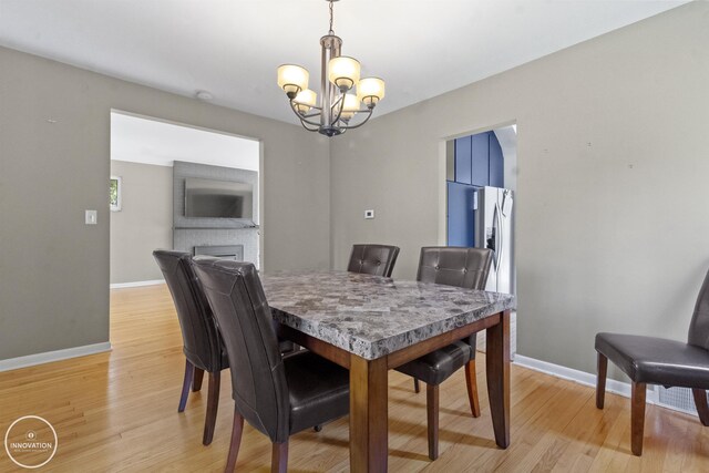 35727 Elm St, Wayne, MI 48184 - dining space featuring a chandelier, light wood finished floors, and a brick fireplace