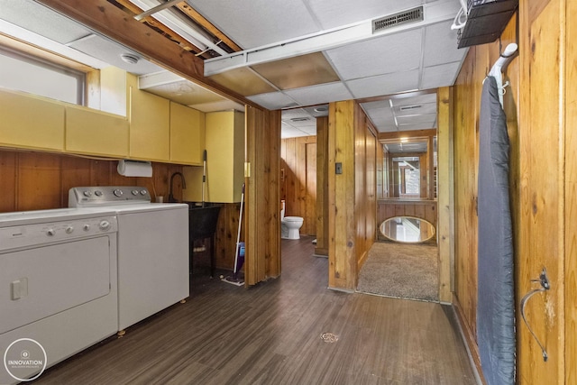 35727 Elm St, Wayne, MI 48184 - laundry area with dark wood-style flooring, wood walls, washing machine and dryer, and cabinet space