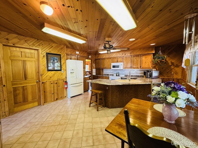 292 Chestnut St, Kingsford, MI 49802 - kitchen featuring white appliances, wooden walls, a peninsula, brown cabinetry, and wooden ceiling