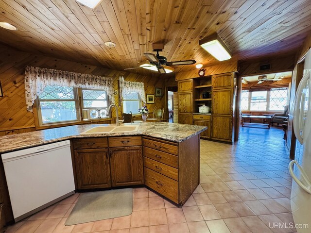 292 Chestnut St, Kingsford, MI 49802 - kitchen with white appliances, wood walls, wooden ceiling, light tile patterned floors, and light stone counters