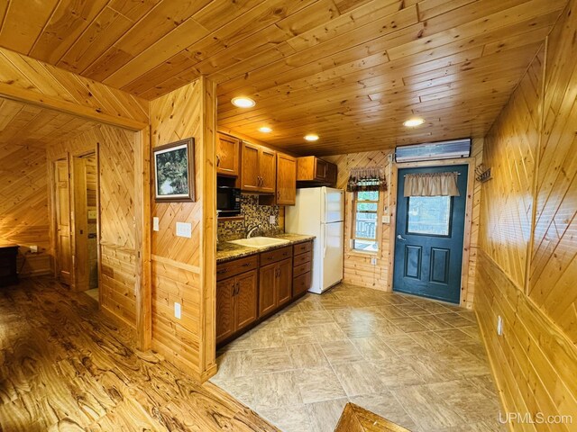 292 Chestnut St, Kingsford, MI 49802 - kitchen featuring freestanding refrigerator, wood walls, brown cabinetry, wood ceiling, and light stone counters
