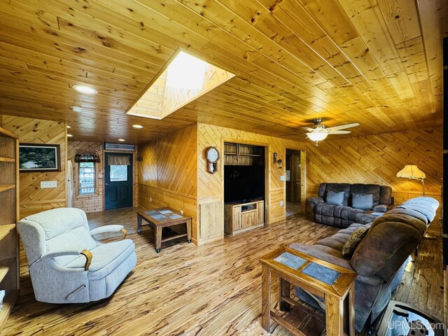 292 Chestnut St, Kingsford, MI 49802 - living room featuring wood walls, wooden ceiling, a skylight, wood finished floors, and a ceiling fan