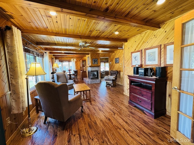 292 Chestnut St, Kingsford, MI 49802 - living room featuring wood finished floors, wood walls, ceiling fan, a multi sided fireplace, and a wooden ceiling with exposed beams