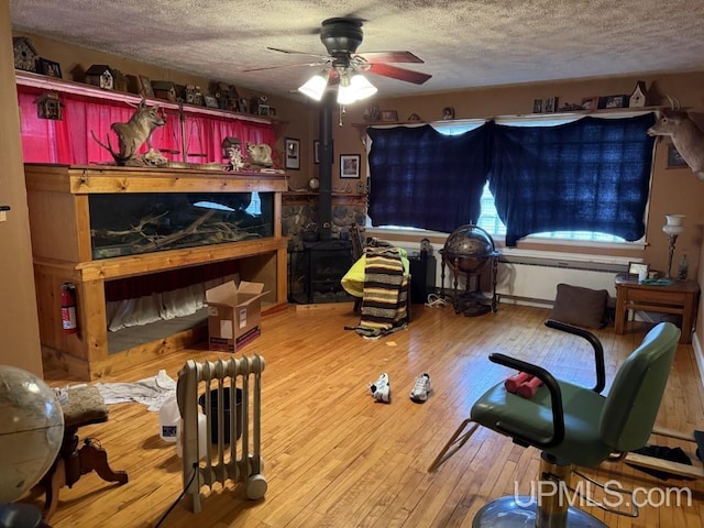 E2903 H44 Rd, Traunik, MI 49891 - living room with a textured ceiling, ceiling fan, and hardwood / wood-style flooring
