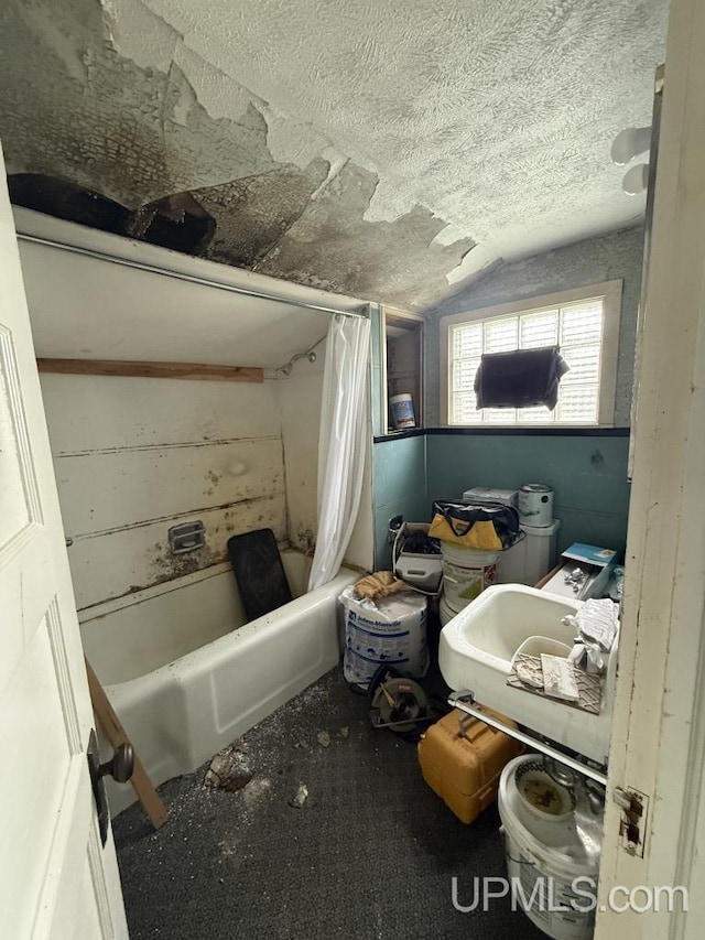 E2903 H44 Rd, Traunik, MI 49891 - full bathroom with shower / bath combo, lofted ceiling, and a textured ceiling